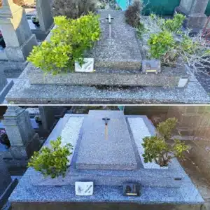 Tombe en pierre grise avec croix centrale, entourée de buissons verts et d’accessoires: plaque et petit souvenir “SOUVENIR” posés sur la dalle, dans un cimetière.
